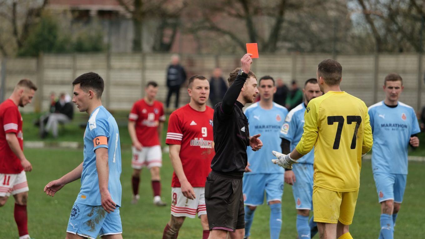 referee showing red card to goalkeeper